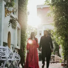 A walking shot of a couple through a European-style alleyway. The warm sunlight and charming architecture create a romantic, storybook feel right in the middle of the city.