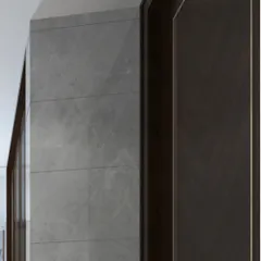 A detail shot showing the precise installation where a grey stone-tiled wall meets a dark wood door frame. This highlights our attention to clean lines and the seamless transition between different high-end materials.
