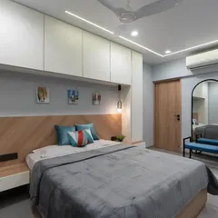 This shot highlights the clever use of space, with storage built in above and around the bed. The combination of white and wood keeps the room feeling bright and warm.