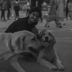 A beautiful black and white photo capturing a moment of pure joy between a visitor and two of our dogs.
