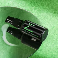 This shot for a men's face serum uses a mirror and a textured green background to create a modern, edgy look. The spilled serum shows the product's texture and color.