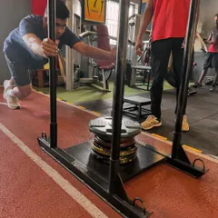 A client digs in for a heavy sled push, a full-body effort that tests strength and willpower.