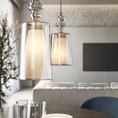 A pair of these reimagined glass pendants over a dining table. The design features an inner diffuser, which creates a soft, warm glow, while the outer clear glass adds depth and reflection.