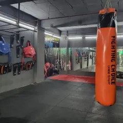 This is where you'll find your strength. Our facility features a dedicated area for striking with various punching bags and protective gear hanging ready for the next session.