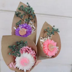 These mini candle bouquets are a perfect small token of affection. Each one features a single, detailed flower-shaped candle wrapped in rustic craft paper with dried flowers. They are a sweet and simple "just because" gift.