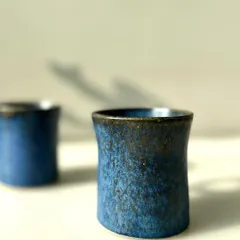 A close-up of the Cobalt Blue cup, showing the subtle texture and the dark, earthy rim where the glaze thins. These small imperfections are the marks of a handmade object and give each piece its own character.