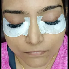 A close-up of the preparation stage. The eye pads are in place to protect the delicate under-eye area and provide a clean canvas for applying the extensions.