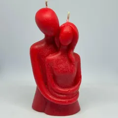 Two flames, one embrace. This red couple candle, showing two figures wrapped in a warm hug, is a beautiful representation of love captured in wax.
