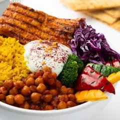 This is my Chicken Shish Tawook Bowl. It's packed with grilled chicken, spiced chickpeas, turmeric rice, fresh veggies, and a dollop of creamy yogurt.