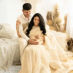 A quiet moment of connection for an expecting couple. This boho-style maternity shoot in a saree combines traditional elegance with a modern, relaxed setting, highlighting the couple's anticipation and joy.