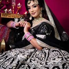 A stunning black velvet lehenga with intricate silver embroidery. The pop of pink from the bangles adds a fun, modern twist to this dramatic look.