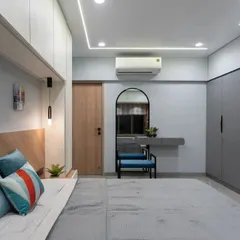 A full view of the pastel bedroom, showcasing the grey wardrobe and the bed with a wooden headboard and integrated storage. The strip lighting in the ceiling provides a soft, ambient glow.