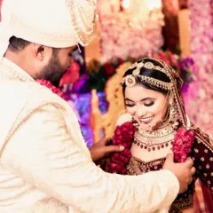 A sweet, unscripted moment during the Varmala ceremony. The groom helps the bride with her garland, and her resulting smile is completely genuine. These are the real moments I love to capture.