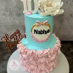 Another angle of the two-tier 10th birthday cake, highlighting the personalized name plaque and the contrast between the two tiers.