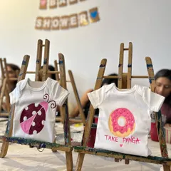 Beyond baking, I also help set up fun activities like this baby onesie painting station for a baby shower. It's a creative and personal touch for any celebration.