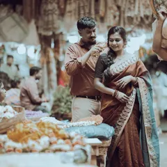 A candid moment captured in a bustling flower market, where the groom-to-be gently places a flower in his fiancée's hair, creating a truly authentic and colorful pre-wedding memory.