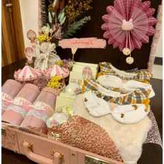Our signature luxury trunk for a baby girl, presented in a lovely shade of pink. This hamper is filled with a curated selection of newborn giveaways, including bibs, decorative items, and keepsakes, all arranged to create a stunning visual impact.