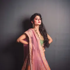 This shot captures a powerful pose from a fashion editorial. The model's strong stance and direct eye contact create a feeling of confidence, while the lighting accentuates the flow and color of the designer outfit.