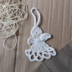 A delicate crochet angel ornament, perfect for hanging on your Christmas tree or as a special gift topper.