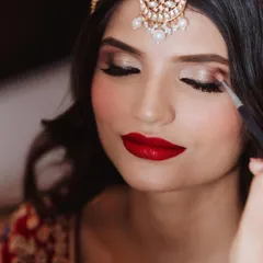 The art of the perfect red lip. This close-up shows the precision and detail that goes into creating a bold, classic bridal look that feels ethereal and glamorous.