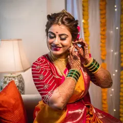 The final touches. This portrait captures the bride adjusting her earring, a simple gesture that signifies the completion of her stunning bridal look.