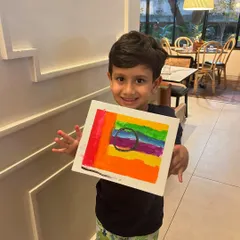 Our little master showing off his amazing abstract rainbow artwork. It's pure joy to see kids express themselves with color at my birthday parties.