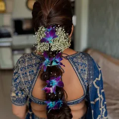 For a touch of natural beauty, I wove fresh purple orchids and baby's breath into this stunning, thick braid. This is a perfect hairstyle for a South Indian bride or anyone wanting a floral touch.