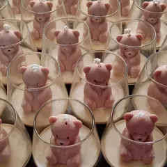 These adorable teddy bear jar candles were created as return favors for a birthday party. Each candle features a cute pink teddy bear inside a glass jar, making for a sweet and memorable keepsake.
