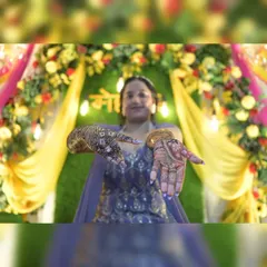 A classic mehendi pose where the bride proudly displays her intricate henna designs. I make sure to get these detailed shots, highlighting the artistry of the mehendi against the festive backdrop.