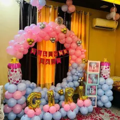 A full room decoration for a baby girl's welcome. This setup includes a large circular balloon arch in pink and grey, "GIRL" foil balloons, "BABY" blocks, and "It's a Girl" themed bottle balloons. I also added rose petals on the floor for a special touch.