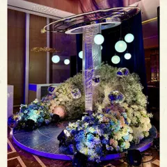 A futuristic, galaxy-inspired installation for a sangeet at Bangalore Golfshire. This piece, with its orbiting spheres and central light column, is surrounded by clouds of baby's breath, creating a focal point that feels both modern and ethereal.
