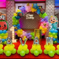 A vibrant Cocomelon party with personalized balloon lettering. I used bright yellow balloons to spell out the birthday girl's name, "PAVANA", in front of a colorful ring backdrop and character cutouts.