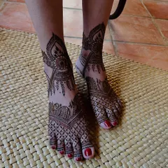 A beautiful example of full-coverage foot mehndi, with intricate jaali work on the toes and a large paisley motif extending up the foot.