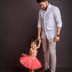 A dad holding his daughter's hand. This full-length portrait captures a simple, loving interaction that speaks volumes about their connection.
