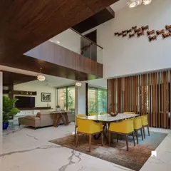A view from the dining area towards the living room, showcasing the seamless flow between spaces, defined by subtle changes in level and material.