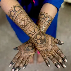 Supriya's stunning engagement mehendi, featuring heavy, intricate work with lotus motifs, paisleys, and geometric patterns covering the full hand and forearm.