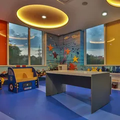 Another view of the ocean-themed room, featuring a car-shaped bookshelf and large windows. The design ensures ample natural light and provides different zones for reading, playing, and learning.