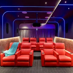 This is our vision for the ultimate home theater experience. We combined bold red leather recliners with dynamic blue profile lighting and professional-grade acoustics to create a vibrant, immersive space for watching movies at home.