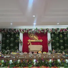 A wider view of the Krishna-themed stage, showing the full floral and prop arrangement.