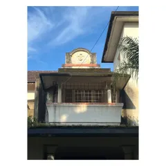 A detail of the building's crest and balcony. The project requires a sensitive approach to preserving original details while upgrading the structure for contemporary use.