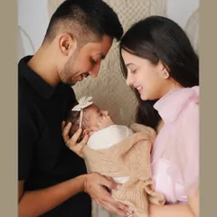 The first family portrait is a memory to hold onto forever. Here, new parents gaze lovingly at their swaddled baby, capturing that initial bond in a simple, beautiful setting.