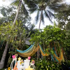 A full view of the musical garden setup, with colorful drapes, hanging bells, and themed props creating a vibrant and playful atmosphere for an outdoor birthday party.