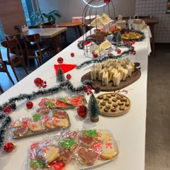 A full view of the high tea buffet we set up for a corporate Christmas party. The table was filled with festive treats, including sandwiches, cookies, and pastries, all surrounded by holiday decorations.
