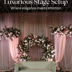 A luxurious stage setup for a reception, where elegance meets emotion. This design features a beautiful floral arch, soft pink draping, and dramatic lighting, creating the perfect focal point for the happy couple.