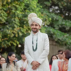 The groom's happy and proud expression as he waits for his bride at the altar.