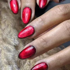 A close-up of the trendy Silver Cat Eye with a Red Jelly finish on durable Polygel extensions. This angle showcases the incredible depth and sparkle created by layering the silver magnetic polish under the translucent red gel.