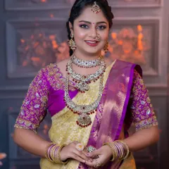 This bride is wearing a stunning Kundan set with ruby-colored stones. The jewellery beautifully complements her yellow and purple saree.