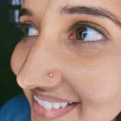 A close-up of a delicate, sparkling nose stud. This is a popular choice for a first nose piercing, and I ensure the placement is neat and flattering.