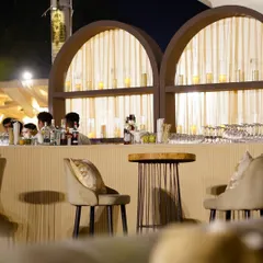 Sit, sip, and savor. Our custom-designed bar counter, with its elegant arched backdrop and warm lighting, ensures that every drink is served in style.