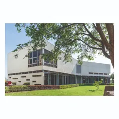 The main office block at the Ajax campus is designed with large glass facades to maximize natural light. The building is set within a lush green lawn, and the master plan ensures that green spaces are interspersed between all built forms.
